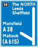 Motorway junction, displaying route number and destination reached as well as destination reached by remaining on the motorway sign